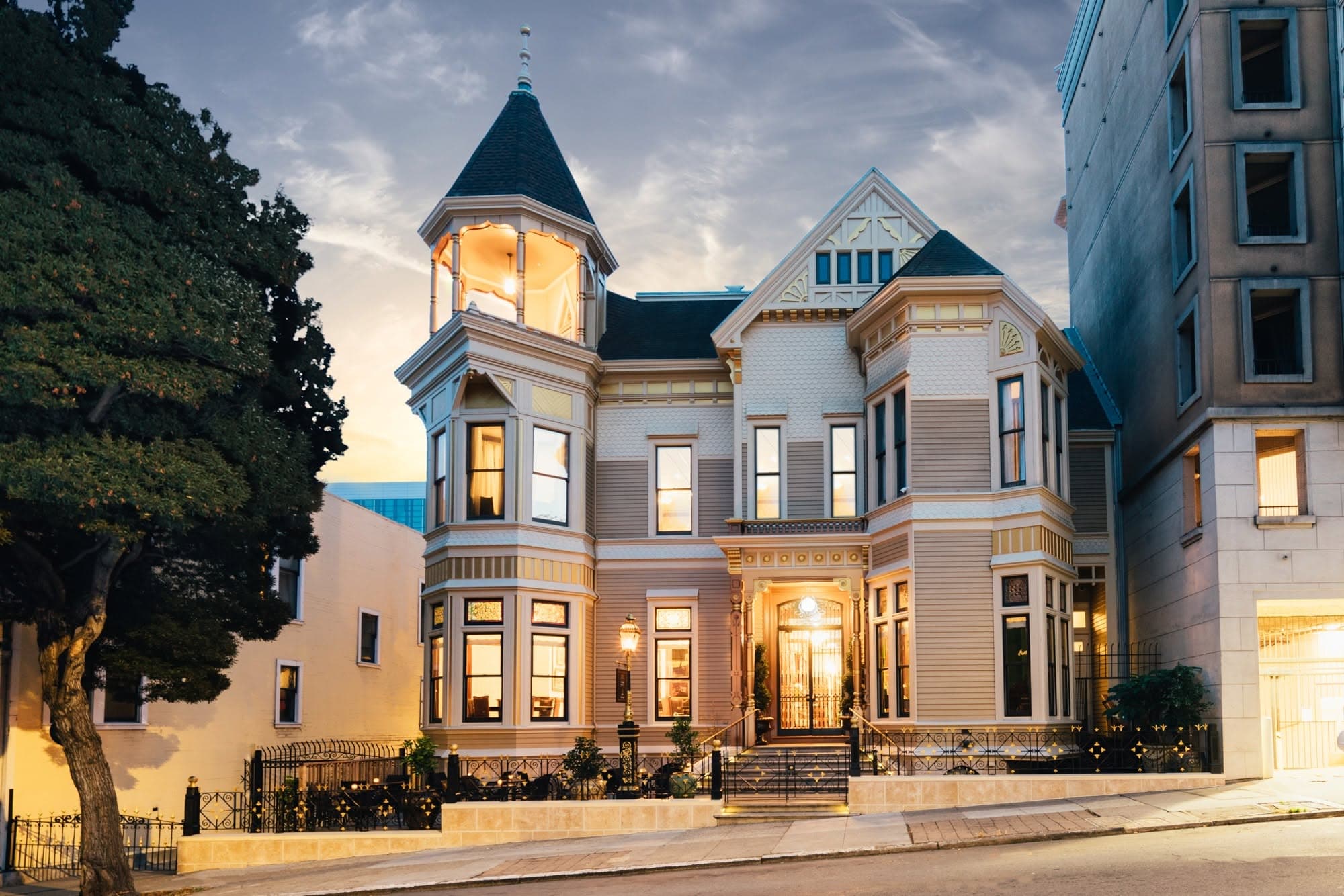 The front of 1409 Sutter Street at dusk: the corner tower, the lit entrance and the steps up from the street.